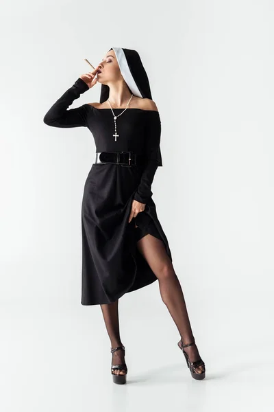 Atraente freira apaixonada em meias fumar maconha conjunta no cinza — Fotografia de Stock