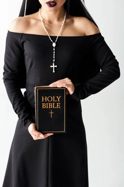 Cropped view of sexy nun in black dress holding bible isolated on grey — Stock Photo