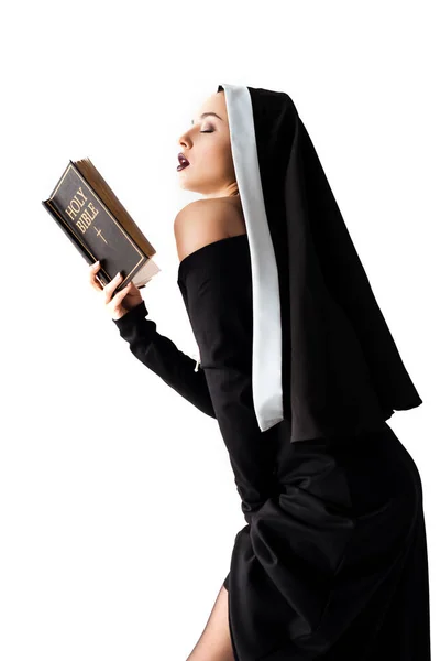 Sexy monja en negro vestido lectura biblia aislado en blanco - foto de stock