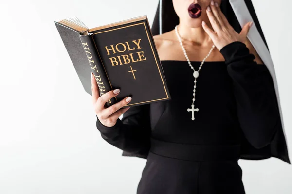 Cropped view of shocked nun in black dress reading bible isolated on grey — Stock Photo