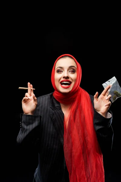Excitado demoníaco mulher segurando maconha conjunta e botões isolados no preto — Fotografia de Stock