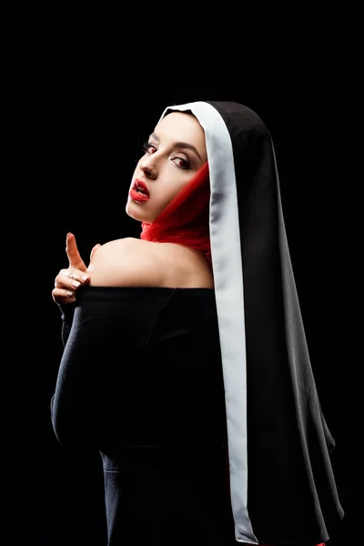 Attraktive sexy Nonne posiert in schwarzem Kleid und rotem Schal, isoliert auf schwarz — Stockfoto