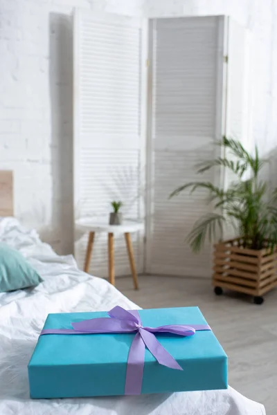 Selektiver Fokus der blauen Geschenkbox auf dem Bett im Zimmer — Stockfoto