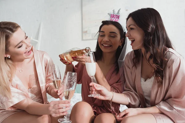 African american bride pouring champagne in glasses with friends at bachelorette party — Stock Photo