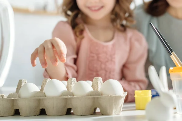 Enfoque selectivo de huevos de pollo cerca de la madre y la hija - foto de stock