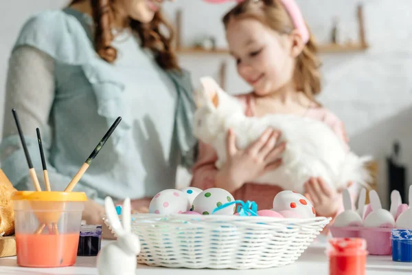 Selektiver Fokus von Zierhasen in der Nähe von Ostereiern, Mutter und Kind — Stockfoto