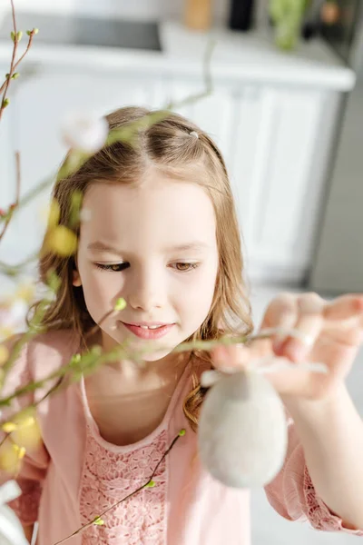 Selektiver Fokus des niedlichen Kindes bei Weidenbrüchen mit dekorativem Osterei — Stockfoto