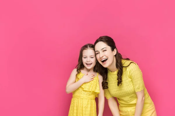 Happy mother and daughter laughing isolated on pink — Stock Photo