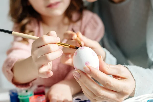 Vue recadrée de mère et fille peignant l'oeuf de Pâques — Photo de stock