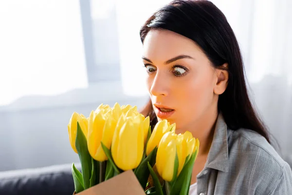 Shocked woman with pollen allergy looking at tulips — Stock Photo