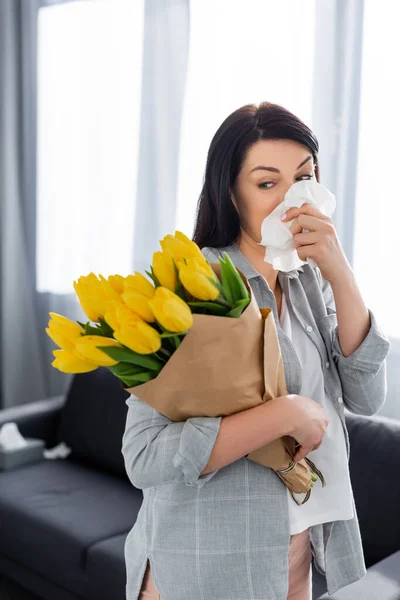 Donna con allergia al polline e naso che cola guardando i tulipani — Foto stock