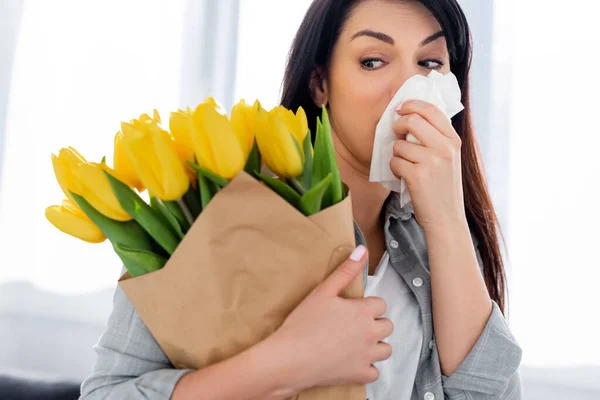 Mulher atraente com alergia ao pólen olhando para tulipas — Fotografia de Stock