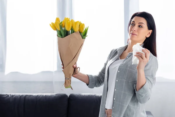 Mulher assustada com alergia ao pólen olhando para tulipas — Fotografia de Stock