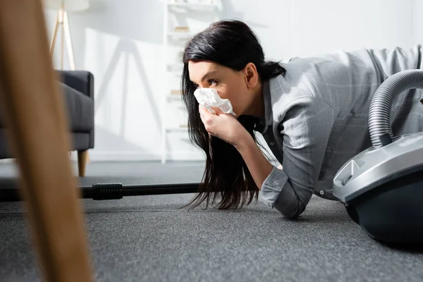 Foyer sélectif de la femme allergique couvrant la bouche avec une serviette et tenant aspirateur — Photo de stock