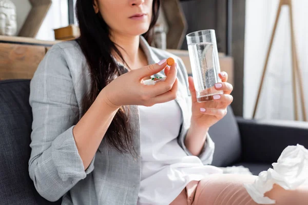 Обрізаний вид алергії жінка тримає таблетку і склянку води — стокове фото