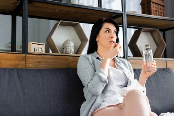 Allergic woman taking pill while holding glass of water — Stock Photo