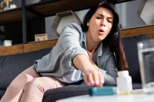 Selektiver Fokus von Frauen mit Asthma, die husten, während sie nach dem Inhalator greifen — Stockfoto