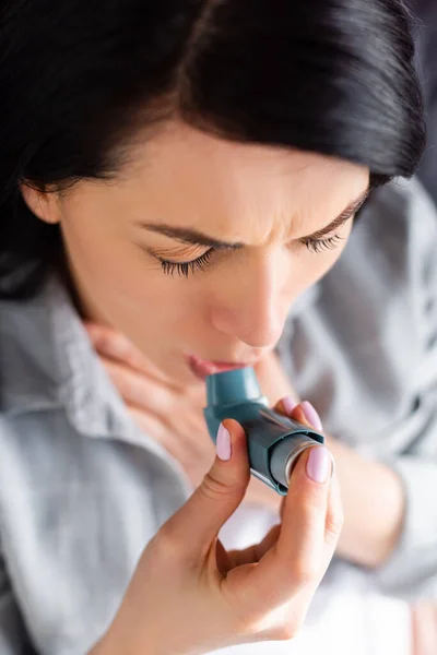 Vista superior de la mujer con asma usando inhalador en casa - foto de stock
