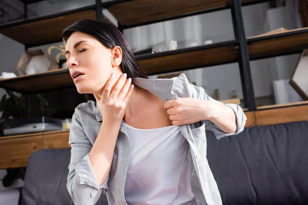 Астматичная женщина с закрытыми глазами трогает шею — стоковое фото