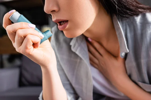 Vista ritagliata della donna malata che tiene l'inalatore a casa — Foto stock