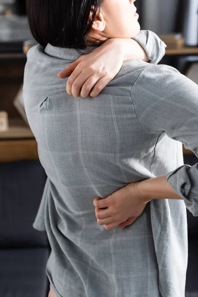 Cropped view of woman with allergy scratching back at home — Stock Photo