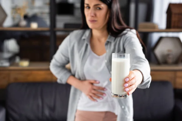 Foco seletivo da mulher com intolerância à lactose segurando vidro de leite — Fotografia de Stock