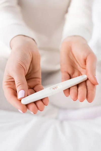 Visão recortada da mulher segurando teste de gravidez em mãos — Fotografia de Stock