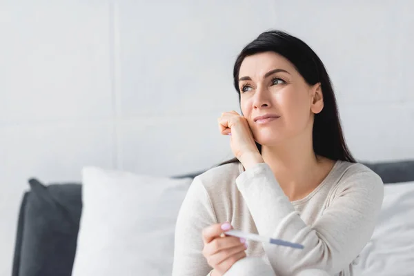 Upset woman crying while holding pregnancy test with negative result — Stock Photo