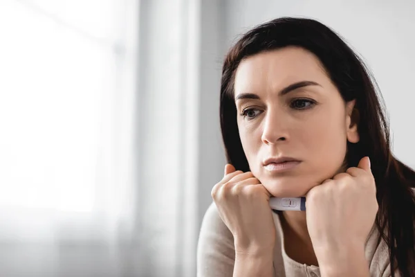 Mujer decepcionada sosteniendo la prueba de embarazo con resultado negativo - foto de stock