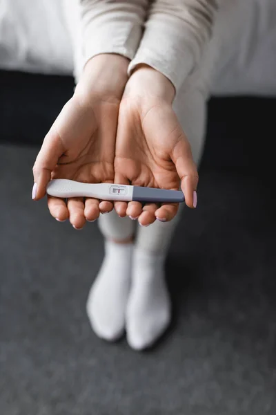 Cropped view of woman holding pregnancy test with negative result in hands — Stock Photo