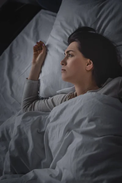 Vue du dessus de la femme bouleversée ayant l'insomnie et couché sur le lit — Photo de stock