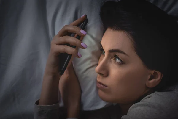 Top view of awake woman with insomnia using smartphone — Stock Photo