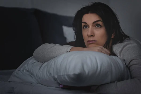 Selective focus of dissatisfied woman having insomnia while lying on bed at night — Stock Photo