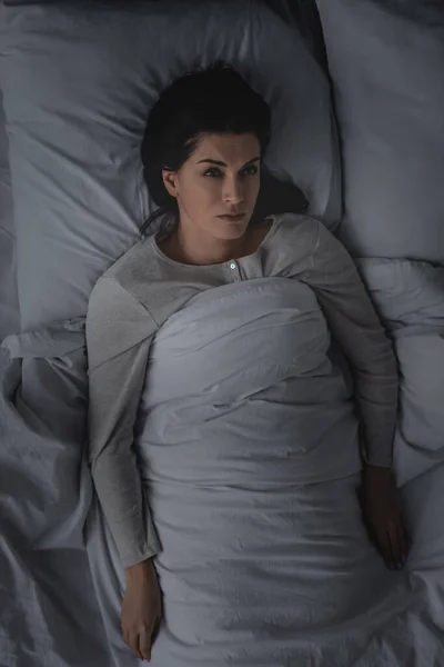 Vista dall'alto della donna con disturbi del sonno sdraiata sul letto — Foto stock