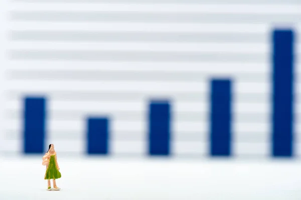 Selective focus of doll on white surface with charts at background, concept of equality — Stock Photo