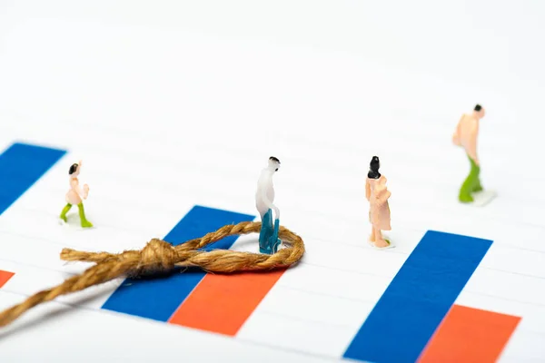 Selective focus of people figures near twine with knot on charts on white surface, concept of equality — Stock Photo