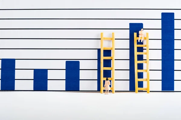 Люди фігури зі сходами біля діаграм на білій поверхні, концепція рівності — стокове фото