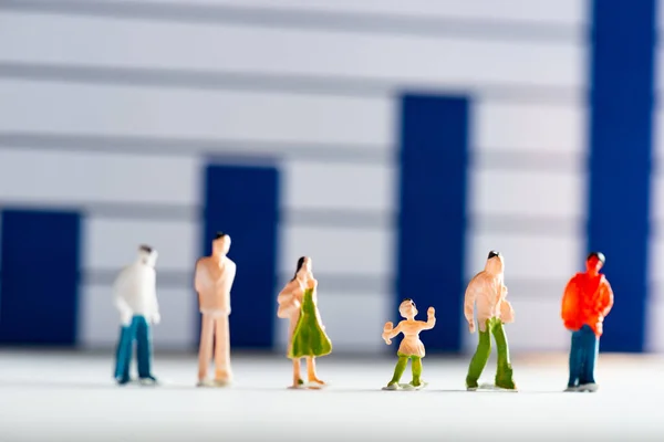 Selective focus of people figures on white surface with analytics graphs at background, concept of equality — Stock Photo