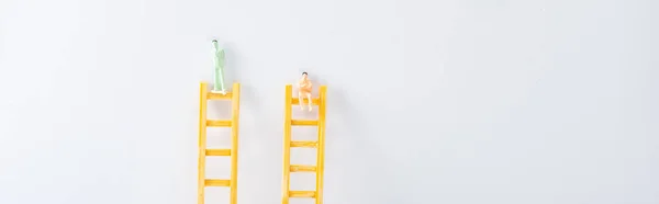 Plan panoramique de deux personnages sur des échelles sur fond blanc, concept de droits à l'égalité — Photo de stock