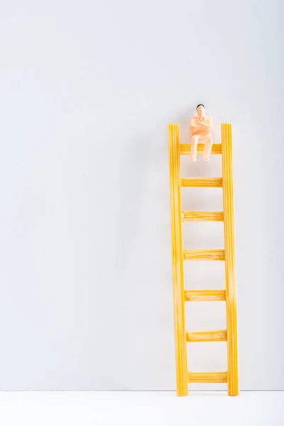 Vista de cerca de muñeca en escalera sobre superficie blanca sobre fondo gris, concepto de derechos de igualdad - foto de stock