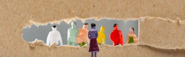 Conceito de direitos sociais com figuras de pessoas perto de buraco em papelão isolado em cinza, tiro panorâmico — Fotografia de Stock