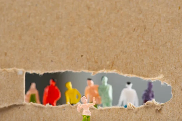 Vista de perto de brinquedo perto de papelão com buraco e silhuetas de pessoas figuras isoladas em cinza, conceito de direitos sociais — Fotografia de Stock