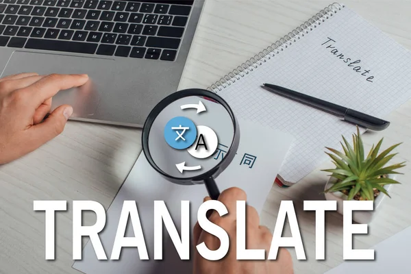 Cropped view of translator working with hieroglyphics, laptop and magnifying glass, translate illustration — Stock Photo