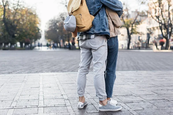 Vista recortada de pareja abrazándose con mochila en Europa - foto de stock