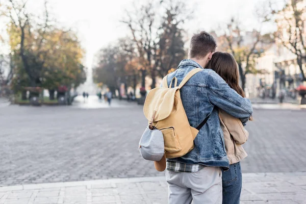 Homem com mochila abraçando com namorada na Europa — Fotografia de Stock