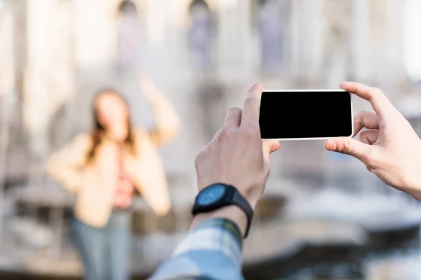 Vue recadrée de l'homme prenant une photo de la femme à l'aide d'un smartphone — Photo de stock