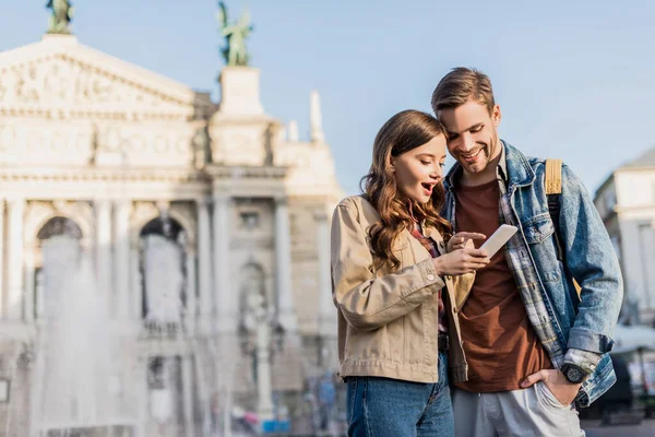 Glückliches und aufgeregtes Paar nutzt Smartphone in der Stadt — Stockfoto