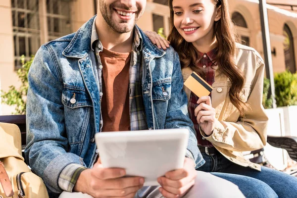 Vista cortada do casal sorrindo e segurando cartão de crédito e tablet digital — Fotografia de Stock