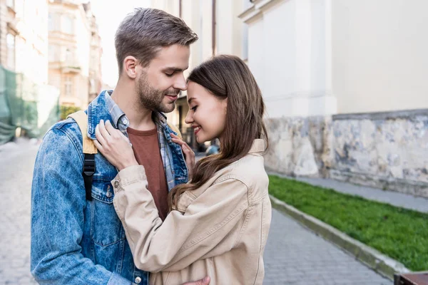 Foco seletivo de abraços de casal e sorrisos na cidade — Fotografia de Stock