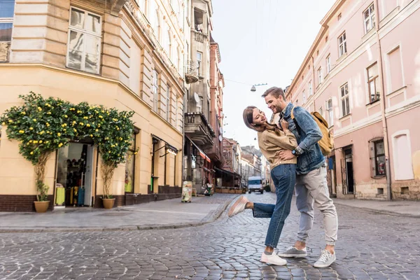 Selective focus of couple having fun and looking at each other in city — Stock Photo